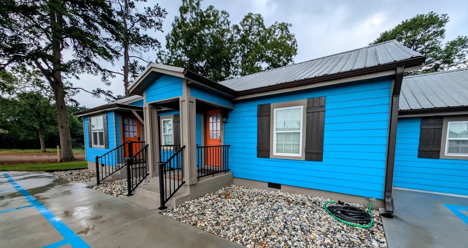 Blue cabin exterior with orange door at Hutch's RV Park